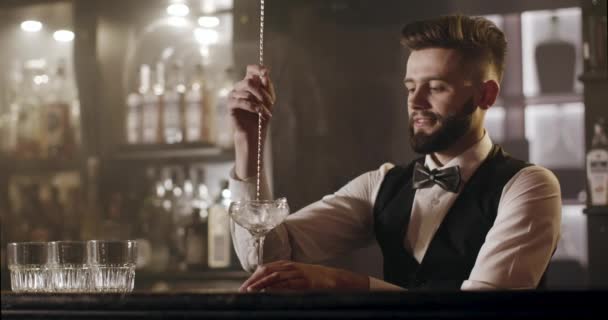De barman draait het ijs in glas met de barlepel. 4k - Video