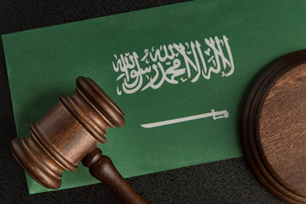 Puinen nuija oikeutta Saudi-Arabian lippu. Lakikirjasto. Oikeuden ja oikeuden käsite - Valokuva, kuva