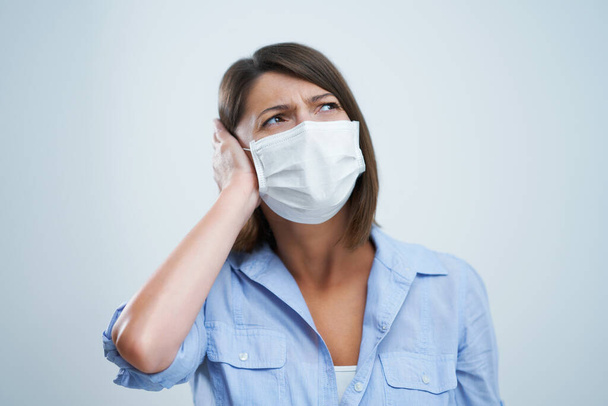 Aantrekkelijke vrouw dragen beschermende masker geïsoleerd over witte achtergrond - Foto, afbeelding