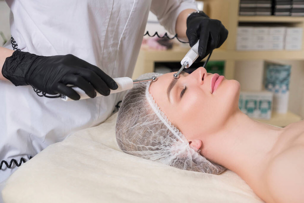 Cosmetologist médico fazer ultra-som descascamento para uma cliente mulher em sua clínica. - Foto, Imagem
