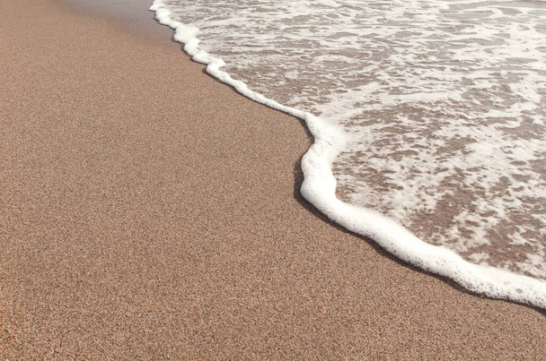 Волна отступает в коричневом песке. Летний пейзаж. Средиземное море. Каталония. Испания
. - Фото, изображение