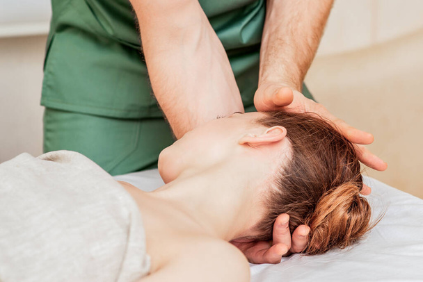 Close up young woman receiving head massage by hands of massage therapist. - Fotoğraf, Görsel