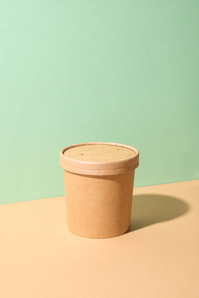 Craft paper soup cup with shadow on green and brown paper.Ecological individual package. Zero Waste. - Valokuva, kuva