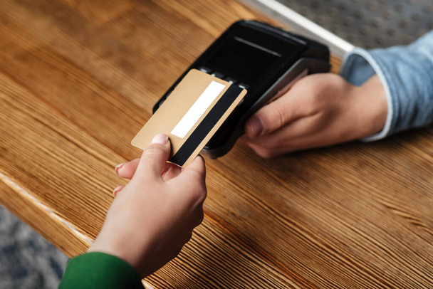 Modern technology for paying bills. Client pays by credit card at contactless terminal - Foto, imagen