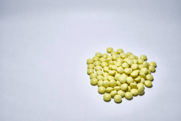 A closeup shot of yellow medical pills isolated on white background - Photo, Image