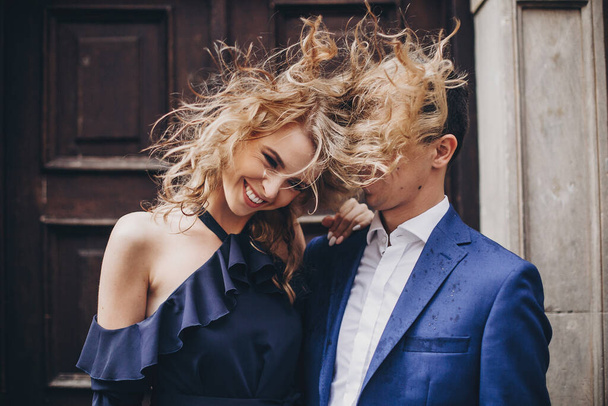 Tyylikäs pari pitää hauskaa ja nauraa Euroopan kaupungin kadulla. Muodikas emotionaalinen nainen heiluttaa hiuksia ja hymyilee miehen kanssa rakastunut. Romanttinen onnen hetki. Ystävänpäivä - Valokuva, kuva