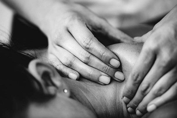 Physiotherapist massaging female patient with injured shoulder blade.  Sports injury treatment. - Fotoğraf, Görsel
