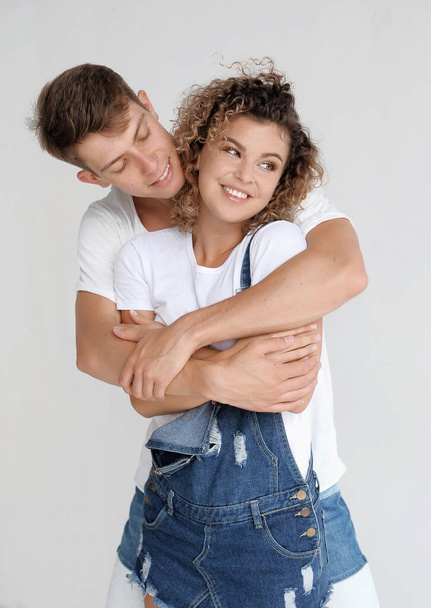 Счастливая пара в джинсовой одежде на белом фоне
 - Фото, изображение