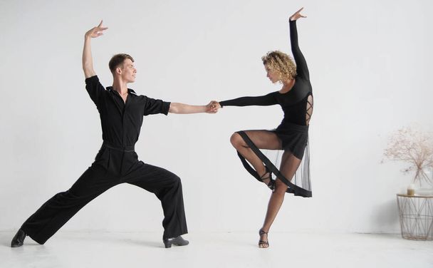 Hermosa pareja con elegantes trajes negros bailando bailes de salón - Foto, Imagen