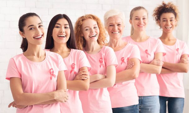 Διαφορετική ομάδα εθελοντών για τον καρκίνο του μαστού που στέκονται μαζί πάνω από λευκό φόντο - Φωτογραφία, εικόνα