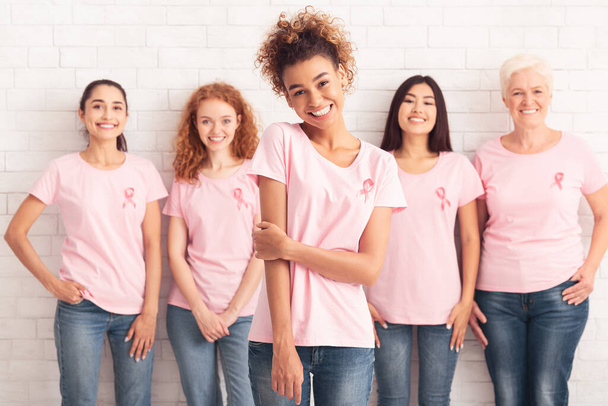 African Girl Standing With Breast Cancer Volunteers Group, White Background - Foto, Imagen