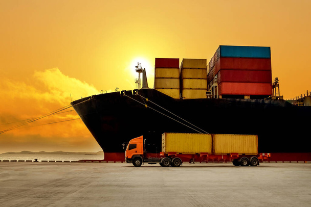 Containerschiffe im Export- und Importgeschäft und in der Logistik. Riesiges Containerschiff beim Entladen und Verladen von Containerfracht am Hafenterminal. Kaikran hebt Container von LKW auf Schiff. - Foto, Bild