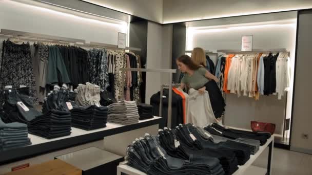 Γυναίκες φίλοι επιλέγουν ρούχα στο κατάστημα - Πλάνα, βίντεο