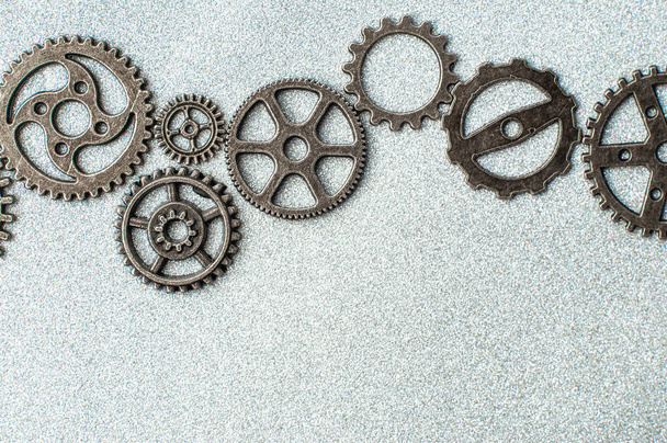 Top closeup view of gear wheels collection on glittering background with blank space for text. Top view, flat lay. - Photo, image