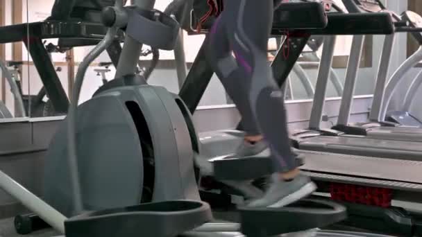 Kobieta biega na bieżni w centrum fitness - Materiał filmowy, wideo