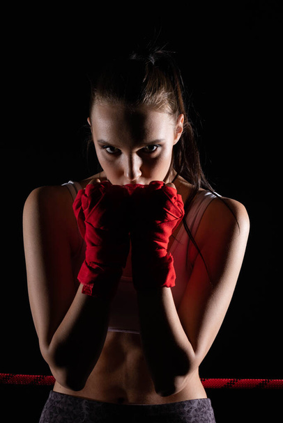 The head is hidden behind the strong guard of a professional sportswoman. A strong and athletic woman in the ring of sports which is MMA. - Foto, immagini