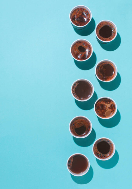 Veel koffiebekers met verschillende soorten koffie, cappuccino en macchiatoon op blauwe achtergrond met lege ruimte voor tekst. Bovenaanzicht, lat lay. - Foto, afbeelding