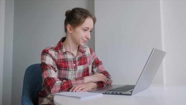 Kobieta korzystająca z laptopa, dzwoniąca przez internet, robiąca notatki, rozmawiająca w domu - Materiał filmowy, wideo