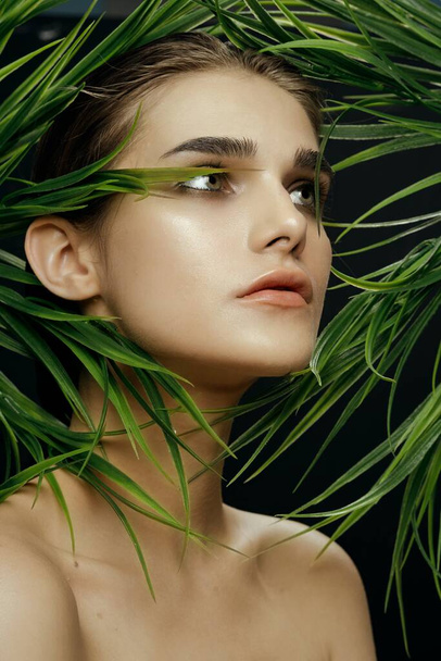 Обрезанный вид женщины с зелеными глазами около листьев
 - Фото, изображение