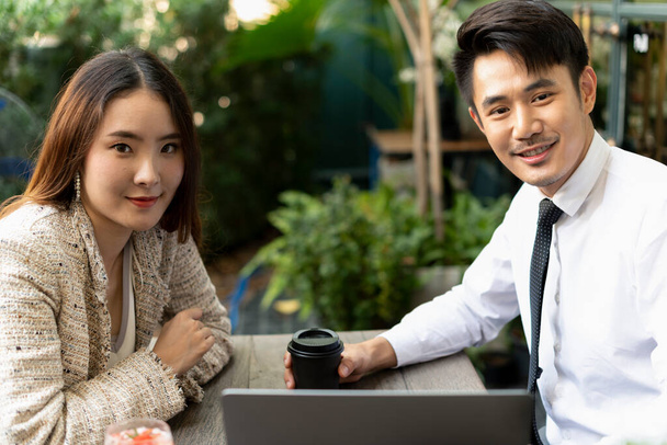 Dois asiáticos pessoas de negócios trabalhando juntos no café, olhando para o computador portátil
. - Foto, Imagem