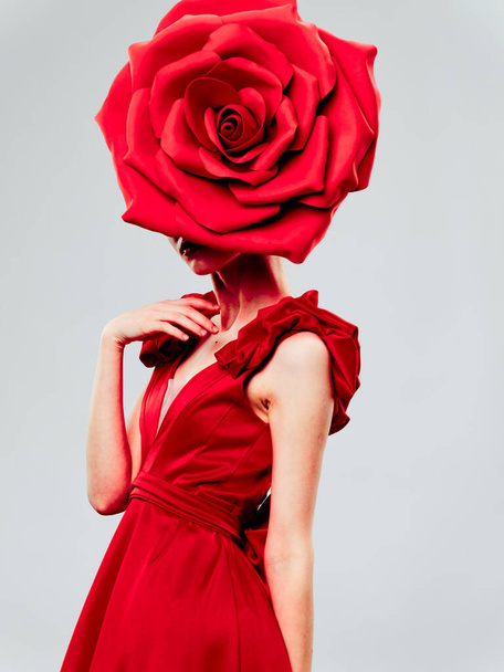 Mulher em um vestido vermelho com uma flor decorativa na cabeça
  - Foto, Imagem