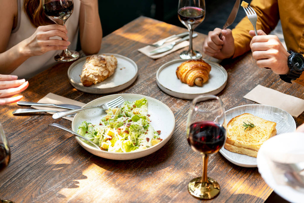 Lidé mají rádi jídlo s červeným vínem. Večírek. Oběd nebo brunch s vínem ve skle. - Fotografie, Obrázek