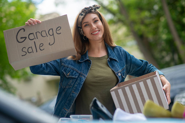Pretty young woman holding a garage sale sign - Zdjęcie, obraz