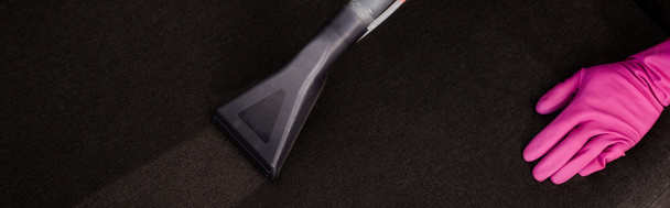 Cultura panorâmica de limpador de luva de borracha aspirando estofos sofá com aspirador de pó
  - Foto, Imagem