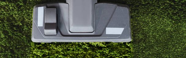 Cultivo panorámico de cepillo de aspiradora sobre alfombra verde
  - Foto, Imagen