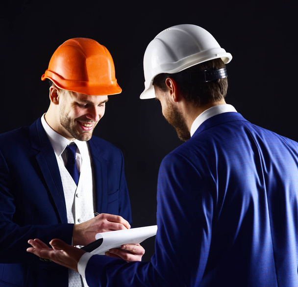 Engineers with smiling faces discuss project. Construction, architecture, work, job concept. - Фото, зображення