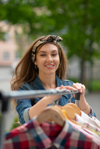 Boa aparência jovem mulher vendendo suas roupas
 - Foto, Imagem