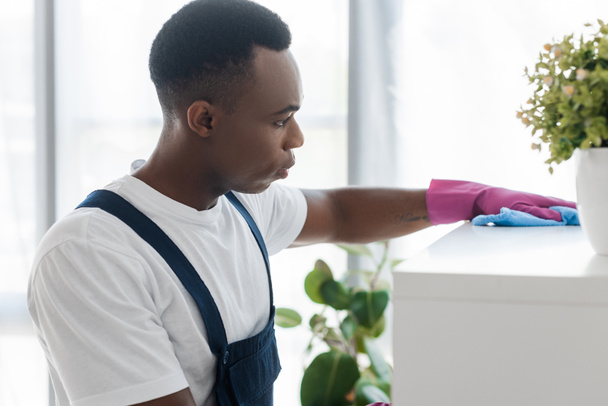 Enfoque selectivo del trabajador afroamericano del servicio de limpieza de oficina armario de limpieza con trapo
  - Foto, Imagen