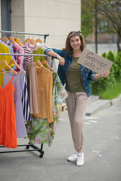 Joyful energetic woman organizing a garage sale - 写真・画像