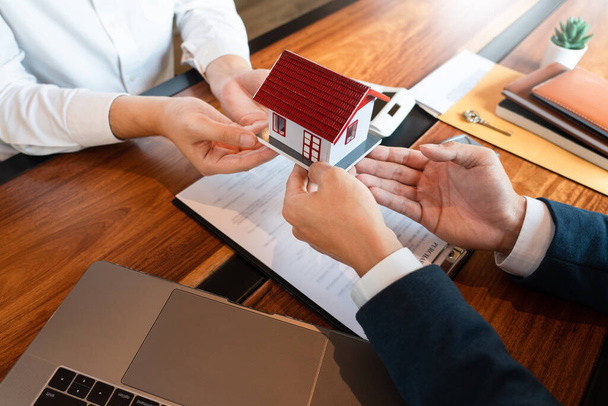 Real Estate broker or sale agent giving consultation to customer about buying house sign agreement document contract. Home loan concept - Photo, image