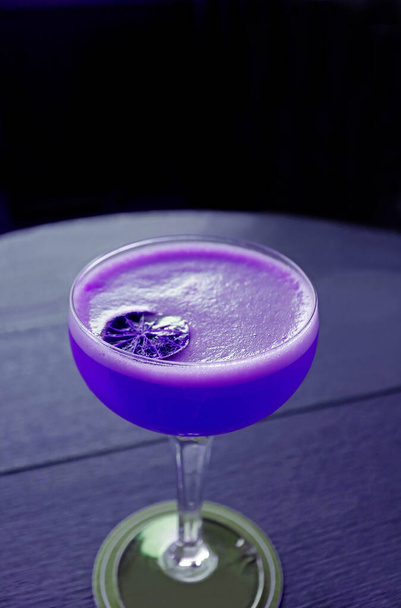 Image verticale du style pop art cocktail coloré violet vif isolé sur la table - Photo, image