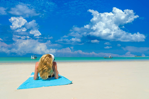 Woman sitting on the beach on her summer holidays - Фото, изображение