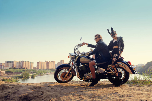 Klasik özel motosikletli seksi iki motorcu, tavşan maskeli bir kız. - Fotoğraf, Görsel