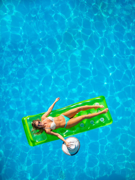 Woman on a lilo at the swimming pool - Photo, image