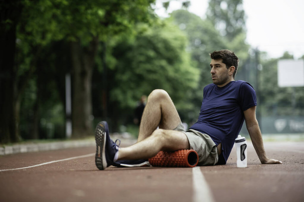 człowiek odpoczywający na torze biegowym po treningu - Zdjęcie, obraz