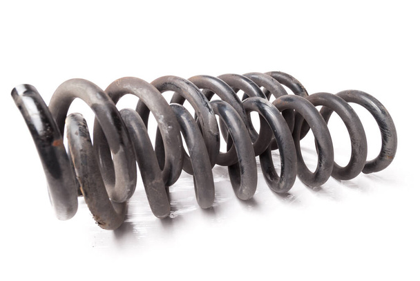 A pair of twisted old iron springs of shock absorbers of a running gear on a white isolated background in a photo studio. A spare part for repairing a car suspension or for sale at an auto-parsing. - Photo, Image
