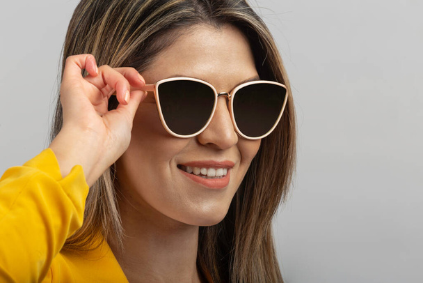 retrato de una mujer latina con gafas de sol y amarillo europeo - Foto, imagen