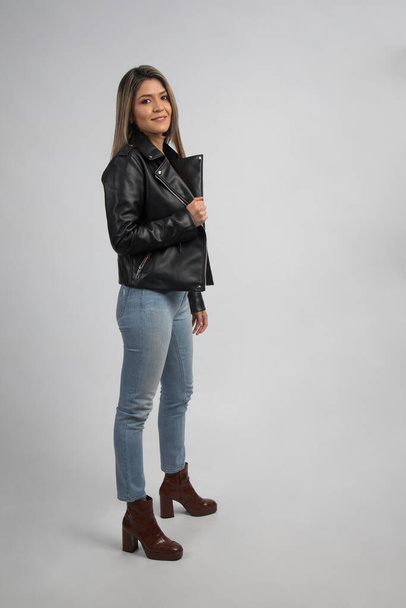 латиноамериканська блондинка модель в джинсах і чорна шкіряна куртка з гарними чоботами, посміхаючись повсякденному вбранні
  - Фото, зображення