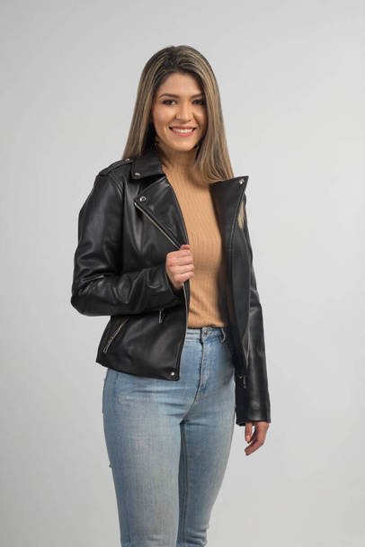 modello biondo latino che indossa jeans e giacca di pelle nera con begli stivali che sorridono abbigliamento casual  - Foto, immagini