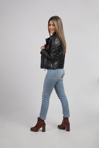 modello biondo latino con jeans e giacca di pelle nera con begli stivali - Foto, immagini