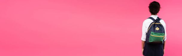 vista trasera de colegiala afroamericana con mochila aislada en rosa, plano panorámico
 - Foto, imagen