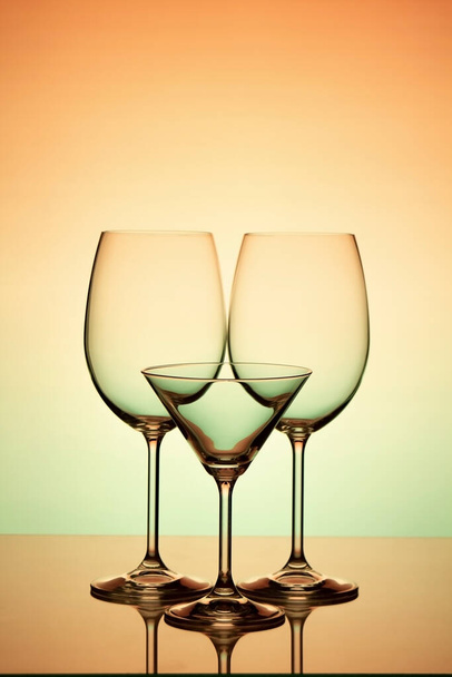 Tři sklenice na víno na oranžovo-zeleném pozadí - Fotografie, Obrázek