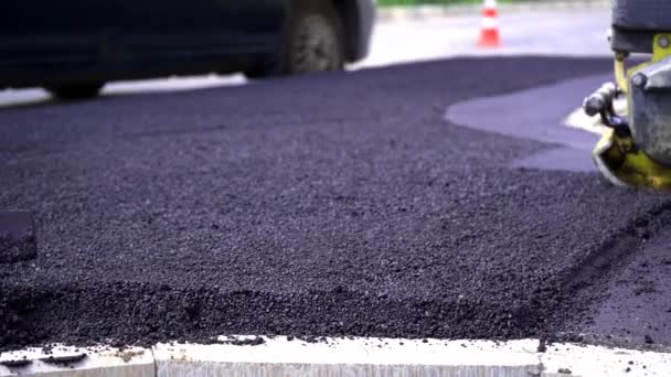 Gros plan, les travailleurs pelletant du gravier noir pour la pose d'asphalte sur la route et le trottoir, travailler à l'extérieur, travailler dur. - Séquence, vidéo