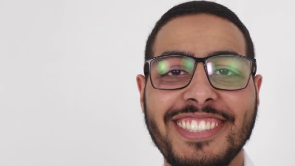 Faccia sorridente di un giovane arabo primo piano. Una persona felice guarda direttamente nell'obiettivo della fotocamera - Filmati, video