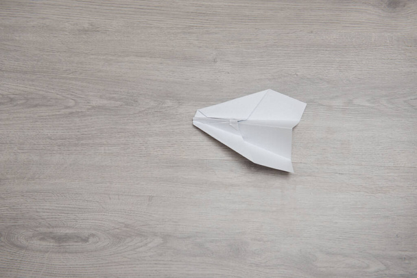 Como fazer o avião de papel de origami passo a passo instrução de foto em mesa de madeira com braços. Passo 12
 - Foto, Imagem