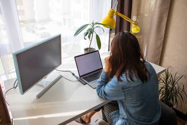 Egy nő, aki laptopon dolgozik az otthoni irodában. Távmunka. távolról - Fotó, kép